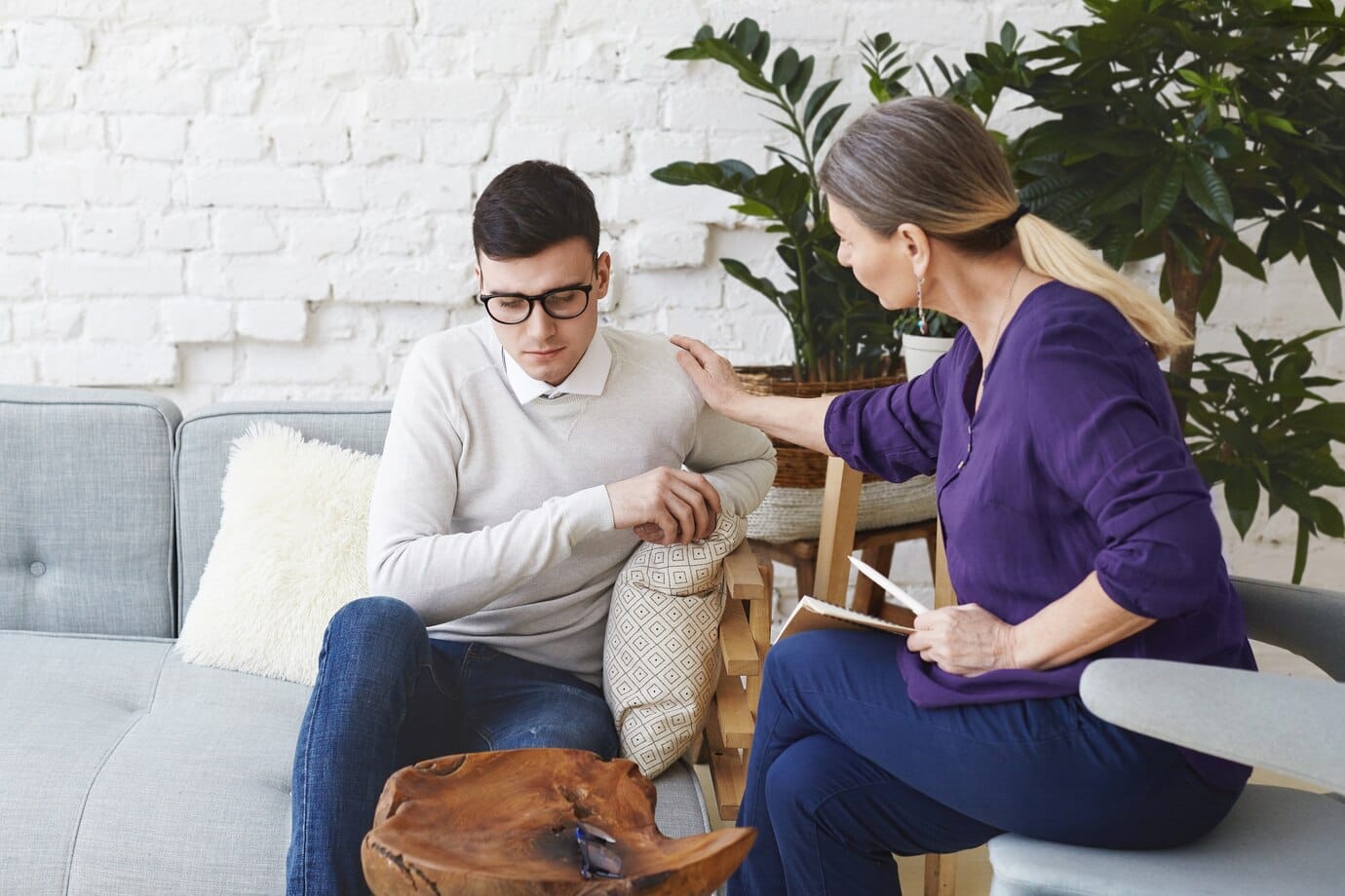 candid-shot-casually-dressed-professional-woman-psychotherapist-her-fifties-touching-her-young-male-patient-by-shoulder-while-having-counseling-session-expressing-sympathy-support_344912-1934